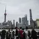 Tourists visiting The Bund line up along the railing facing the Huangpu River and Shanghai's Pudong business district to take photos on Saturday, September, 30, 2017, in Shanghai. Image by Kelsey Kremer. China, 2017.