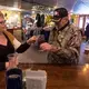 Sheri Rohland shares a toast with customer Garry Jeffers of Sussex at Munson Bridge Winery in Withee. Image by Mark Hoffman. United States, 2019.