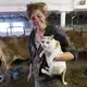 Emily Harris holds 'Shitty Kitty' while taking a break from loading livestock. The barn cat got the name after they found it covered with manure. Image by Mark Hoffman. United States, 2019.