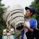 A beauty contest participant sits beside her silver headdress during Torch Festival celebrations in Liangshan prefecture, Sichuan province. Image by Max Duncan. China, 2016.