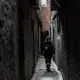 A member of the cleaning cooperative disinfecting the narrow alleys of the slum. Image by Anita Pouchard Serra. Argentina, 2020.