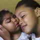 Fabiane Lopes gets medicine for her daughter, Valentina, at their home (left) in Duque de Caxias, a suburb of Rio de Janeiro in southeastern Brazil, while Eduarda Lopes, 9, holds her sister (right). Image by Mark Hoffman. Brazil, 2017.