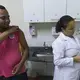 Delvid Santos Melo prepares to receive a yellow fever immunization from clinic worker Tielly Barboga de Souza. Image by Mark Hoffman. Brazil, 2017.