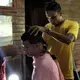 Lazaro Estrada gets a haircut at the camp for Cuban migrants in Gualaca. Image by Mario J. Pentón. Panama, 2017.