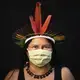 Dilza, 39, of the Sateré Mawé indigenous ethnic group, poses for a portrait wearing the traditional dress of her tribe and a face mask amid the spread of the new coronavirus in Manaus, Brazil, Wednesday, May 27, 2020. Image by Felipe Dana / AP Photo. Brazil, 2020.