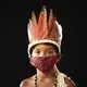 Six-year-old Elano de Souza, of the Sateré Mawé indigenous ethnic group, poses for a portrait wearing the traditional dress of his tribe and a face mask amid the spread of the new coronavirus in the Gaviao community near Manaus, Brazil, Friday, May 29, 2020. Image by Felipe Dana / AP Photo. Brazil, 2020.