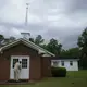 Eddie Keith, 65, of Dawson, Ga., locks the church doors as he leaves on Sunday, April 19, 2020, in Dawson, Ga. He visits his pastor's church a couple times a week. Keith says as he loaded the body of his pastor into the hearse, he talked to him, 'I didn't think you'd leave me so early,' he remembers saying. 'I thought we were going to grow old together.' Image by Brynn Anderson / AP Photo. United States, 2020.