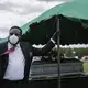 Cordarial O. Holloway wears a protective mask as his tie blows in the wind after a funeral at Cedar Hill Cemetery, on Saturday, April 18, 2020, in Dawson, Ga. Image by Brynn Anderson / AP Photo. United States, 2020.