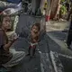 A homeless woman in Malate seeks change to buy food for her toddler. The streets of Manila are home to thousands of homeless Filipinos who sleep on the sidewalks, sea walls, under awnings and in stairwells - anywhere they can get rest without being told to move on. Image by James Whitlow Delano. Philippines, 2018. 