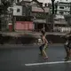 Boys, armed with a knife and a rusty machete, emerge from a slum in Tondo, Manila, to pursue a rival across a highway, through rush-hour traffic to attack him. Image by James Whitlow Delano. Philippines, 2018. 