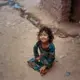 A girl in the I-12 Afghan settlement plays during the early morning. Image by Sara Hylton. Pakistan, 2018.