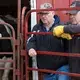 A pair of men watch bidding on livestock during an auction. Image by Mark Hoffman. United States, 2019.