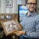 Gleidson Gouveia, an employee of Michael Lee, the owner of the Hamburg Inn No. 2, holds an old photo that hangs on the wall of the Hamburg Inn on Rochester Avenue on Friday, Oct. 6, 2017, in Iowa City. This second location of the restaurant was the first of many expansions planned for the U.S. and China. Image by Kelsey Kremer. United States, 2017.