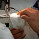 ASHEBORO, NORTH CAROLINA - Maria Reyes Alonso a sewer at the Bossong Medical plant in Asheboro, N.C. sews elastic bands onto masks on Thursday, July 16, 2020. Image by Jeff Siner/The Charlotte Observer/North Carolina News Collaborative. United States, 2020.