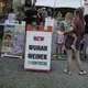 Visitors to the Perry State Fair walk past a food stand selling the “Wuhan Weiner,” in New Lexington, Ohio. Image by Wong Maye-E/AP Photo. United States, 2020.