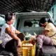 Reggie (left) sits at the back of a truck to distribute relief goods to the village. Image by Xyza Bacani. Philippines, 2020.
