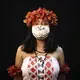 Yusuro Dupohtiro, 15, of the Dessana and Sateré Mawé indigenous ethnic groups, poses for a portrait wearing the traditional dress of her tribe and a face mask amid the spread of the new coronavirus in Manaus, Brazil, Wednesday, May 27, 2020. Image by Felipe Dana / AP Photo. Brazil, 2020.