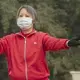 A woman goes through her morning Tai Chi routine in Shijiazhuang’s Ping An Park — exercising her body while trying to protect her lungs. Image by Larry C. Price. China, 2018.