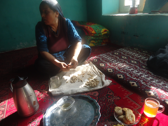 A woman shells almonds in Karaghuzhlah. Image by Anna Badkhen. Afghanistan, 2011.