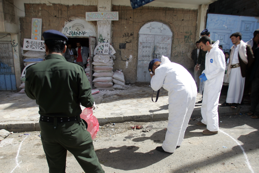 Police and forensic officers gather evidence at the site of a suicide bomb blast in Sana'a Apr. 26, 2010. A suspected Al Qaeda suicide bomber targeted the convoy of the British ambassador to Yemen early on Monday, killing himself and injuring three others, but the envoy was unharmed, Yemeni and British officials said. Image by Khaled Abdullah/Reuters. Yemen, 2010. Media file: yemen police.jpg